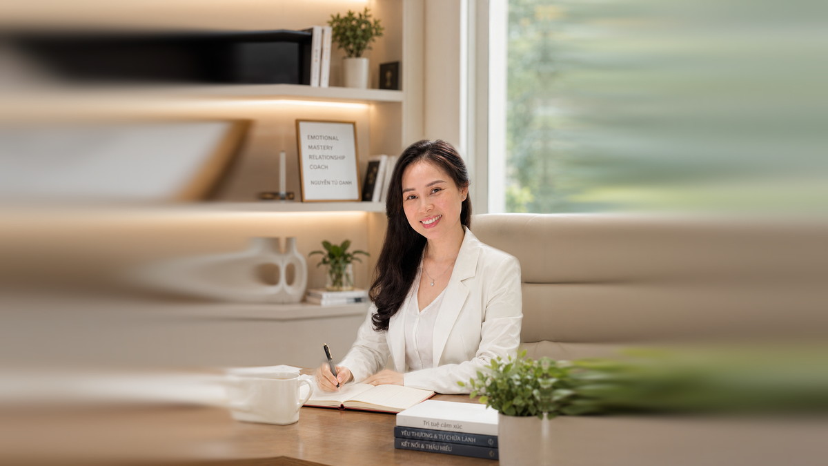 Nguyễn Tú Oanh, Thạc sĩ Tâm lý và Chuyên gia khai vấn quốc tế liên đoàn ICF, ghi chép bên bàn làm việc, sau lưng là kệ sách